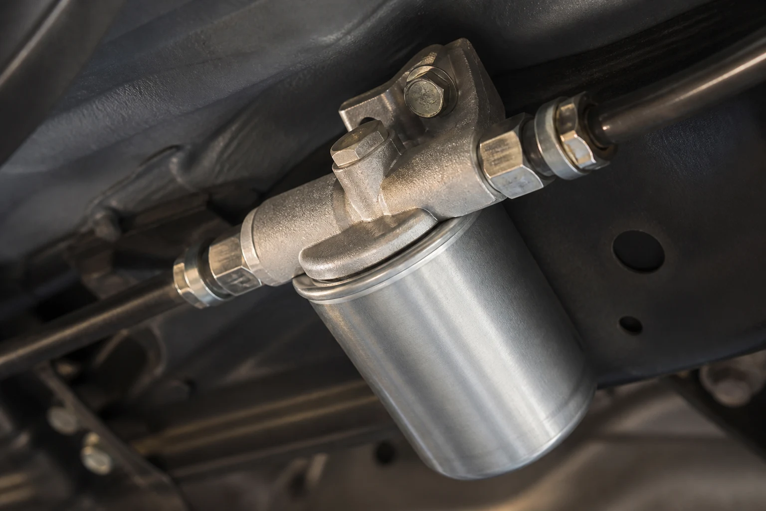Close-up of a vehicle fuel filter, hoses and metal fittings